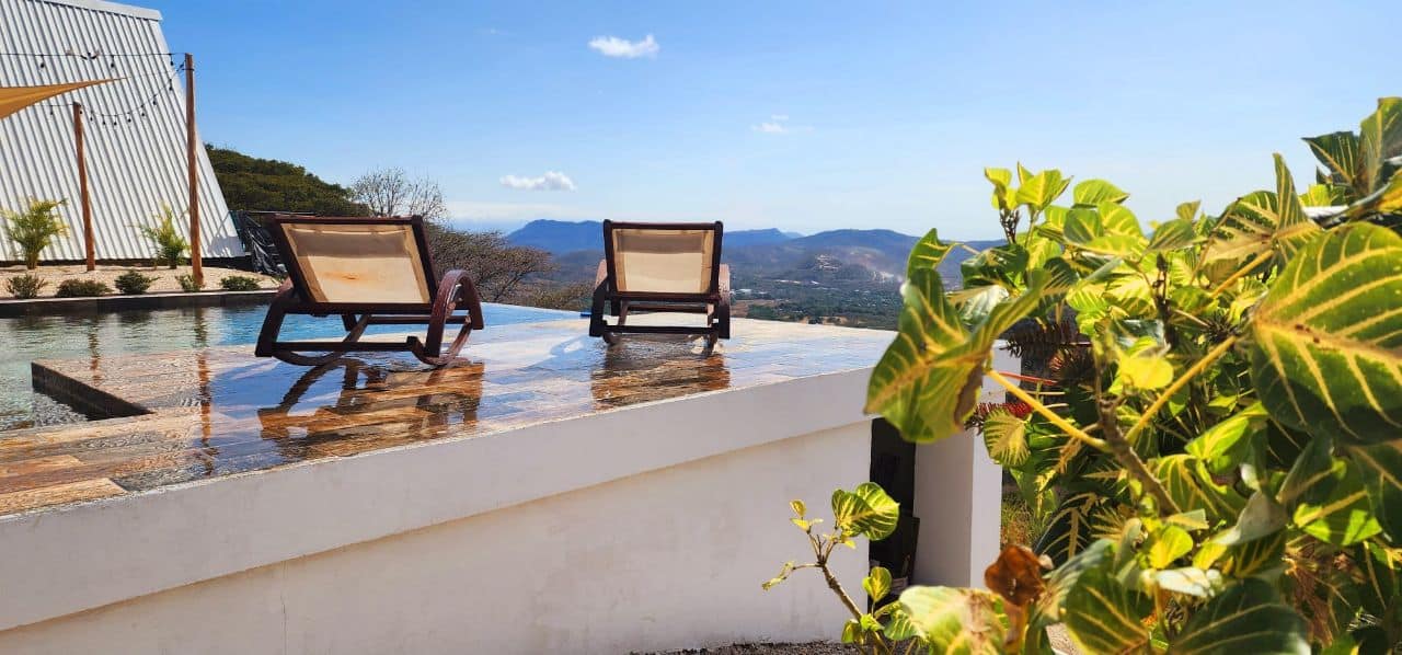 Infinity pool lounge chairs panoramic view Nicoya mountains luxury vacation rental Costa Rica upscale stay