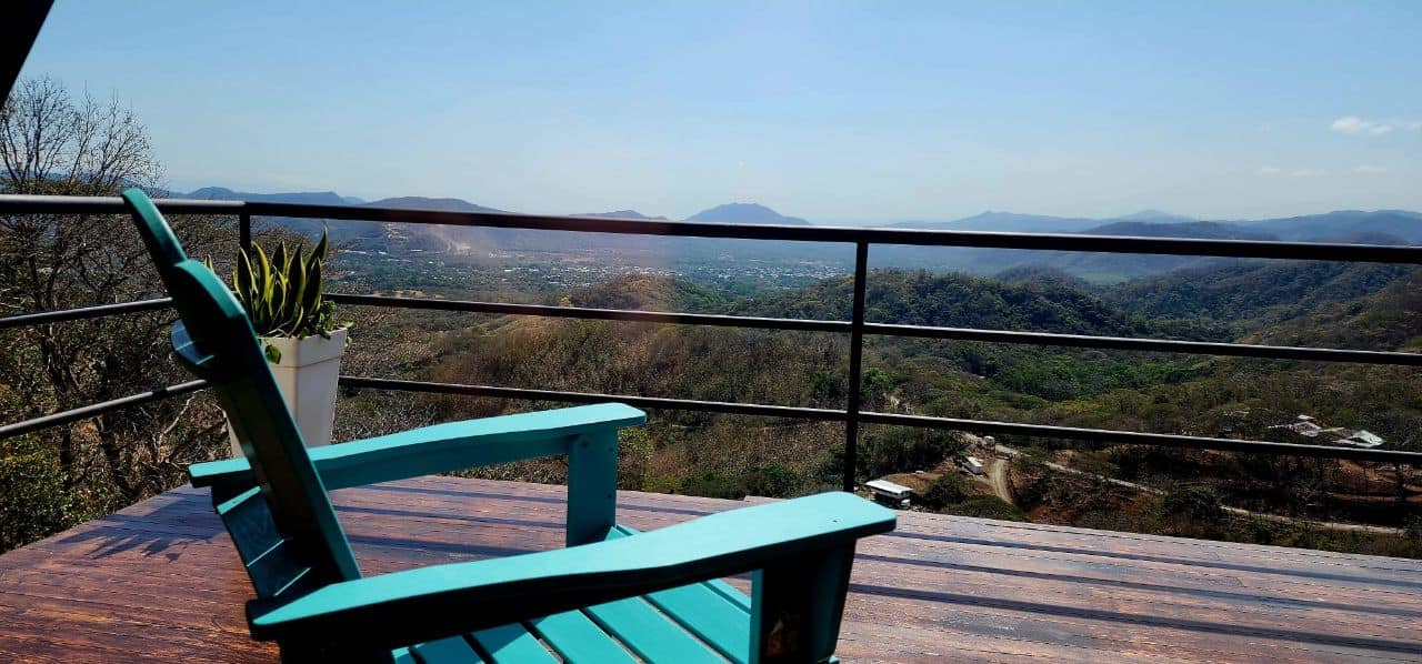 Turquoise Adirondack chair wooden terrace panoramic valley view luxury vacation rental Costa Rica mountain retreat