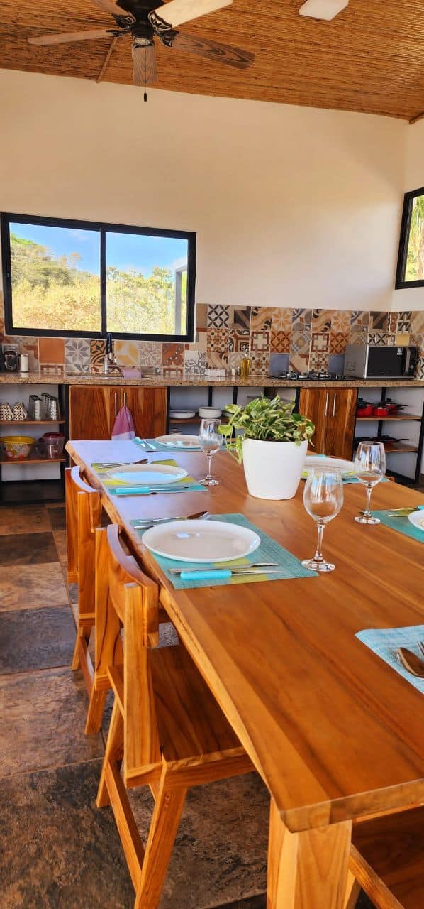 Wooden dining table chairs kitchen artisanal tile backsplash luxury vacation rental Bluesky Lodge Costa Rica