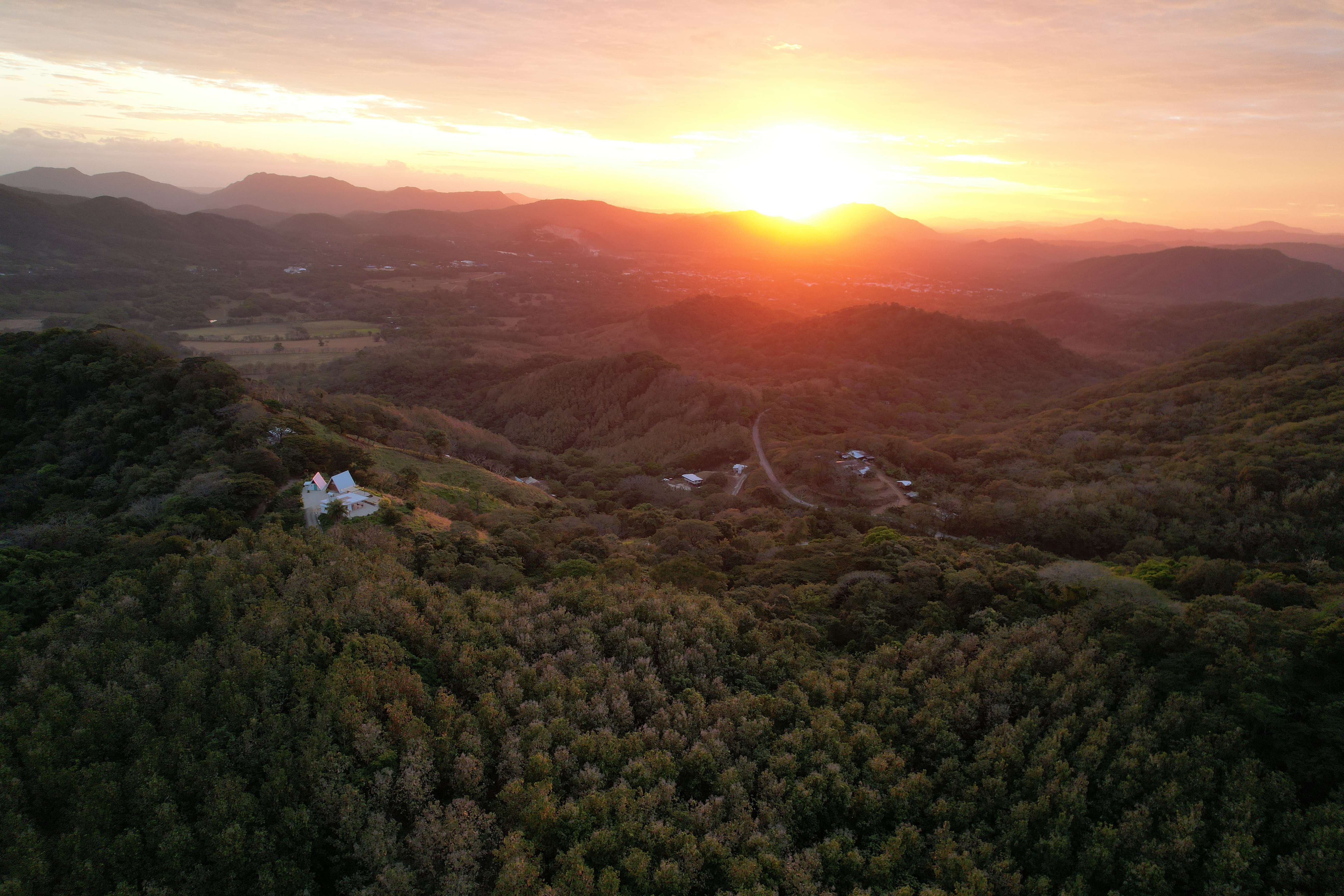Wide aerial view luxury lodge golden hour stunning mountainous landscape Costa Rica vacation rental